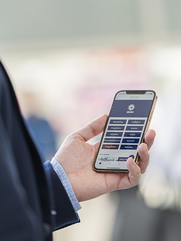 Nahaufnahme eines Menschen, der die SMM Networking-App auf einem Smartphone benutzt.