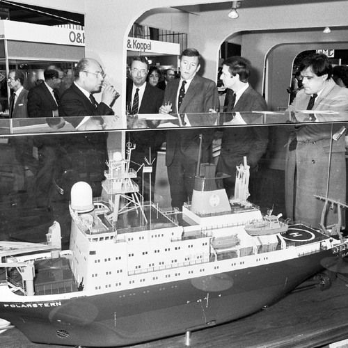 Ein Schwarz-Weiß-Bild eines Ausstellungsstücks auf einer Messe, das ein Modell eines Schiffs zeigt, möglicherweise ein Abbild eines echten Schiffs