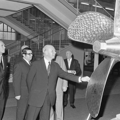 Eine Gruppe von Männern, die sich eine große Turbine anschauen.