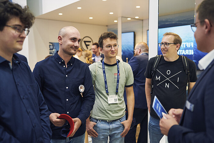 Besuchende unterhalten sich mit Ausstellenden