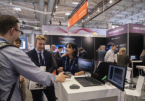 Besuchende und Ausstellende unterhalten sich. 