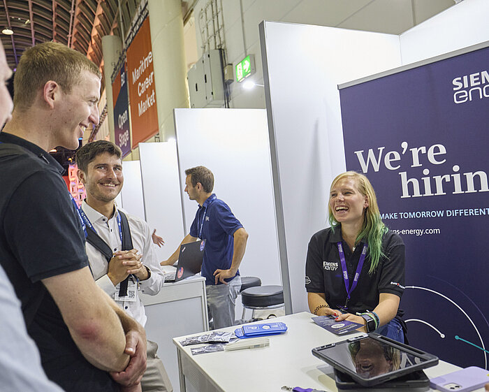 Ausstellende unterhalten sich mit Besuchenden. 