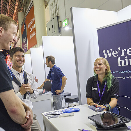 Ausstellende unterhalten sich mit Besuchenden. 
