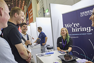 Ausstellende unterhalten sich mit Besuchenden.