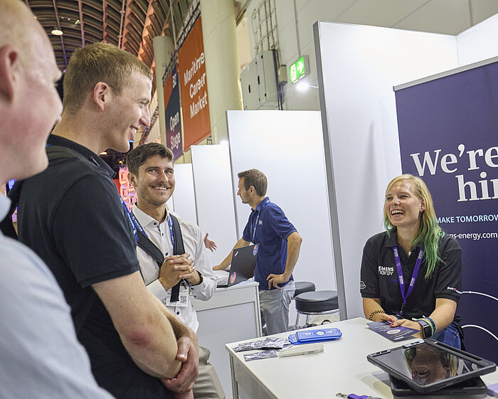 Ausstellende unterhalten sich mit Besuchenden.