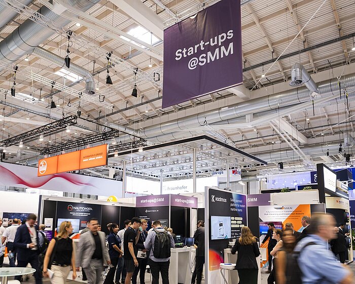  Im Start-up-Bereich sind einzelne Stände zu sehen, die von vielen Besuchenden umgeben sind.