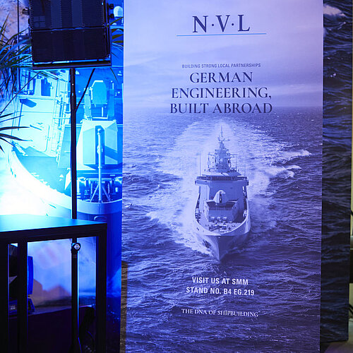 Es ist ein großes Plakat der NVL zu sehen mit der Aufschrift: Building strong local partnerships. German engineering, built abroad.