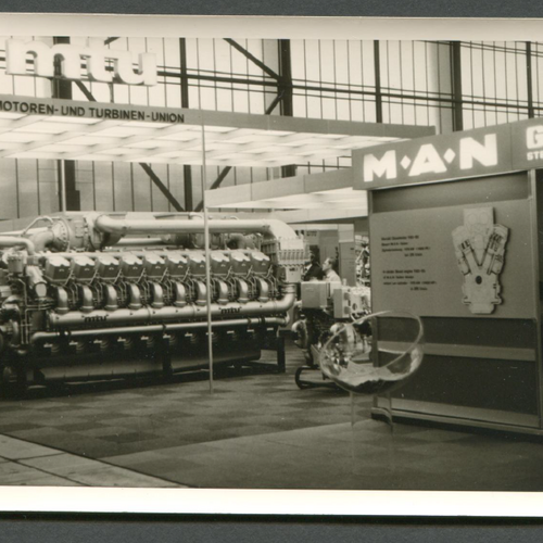 Historisches Bild eines Messestandes der Motoren- und Turbinen-Union, mit einer großen, ausgestellten Turbine.